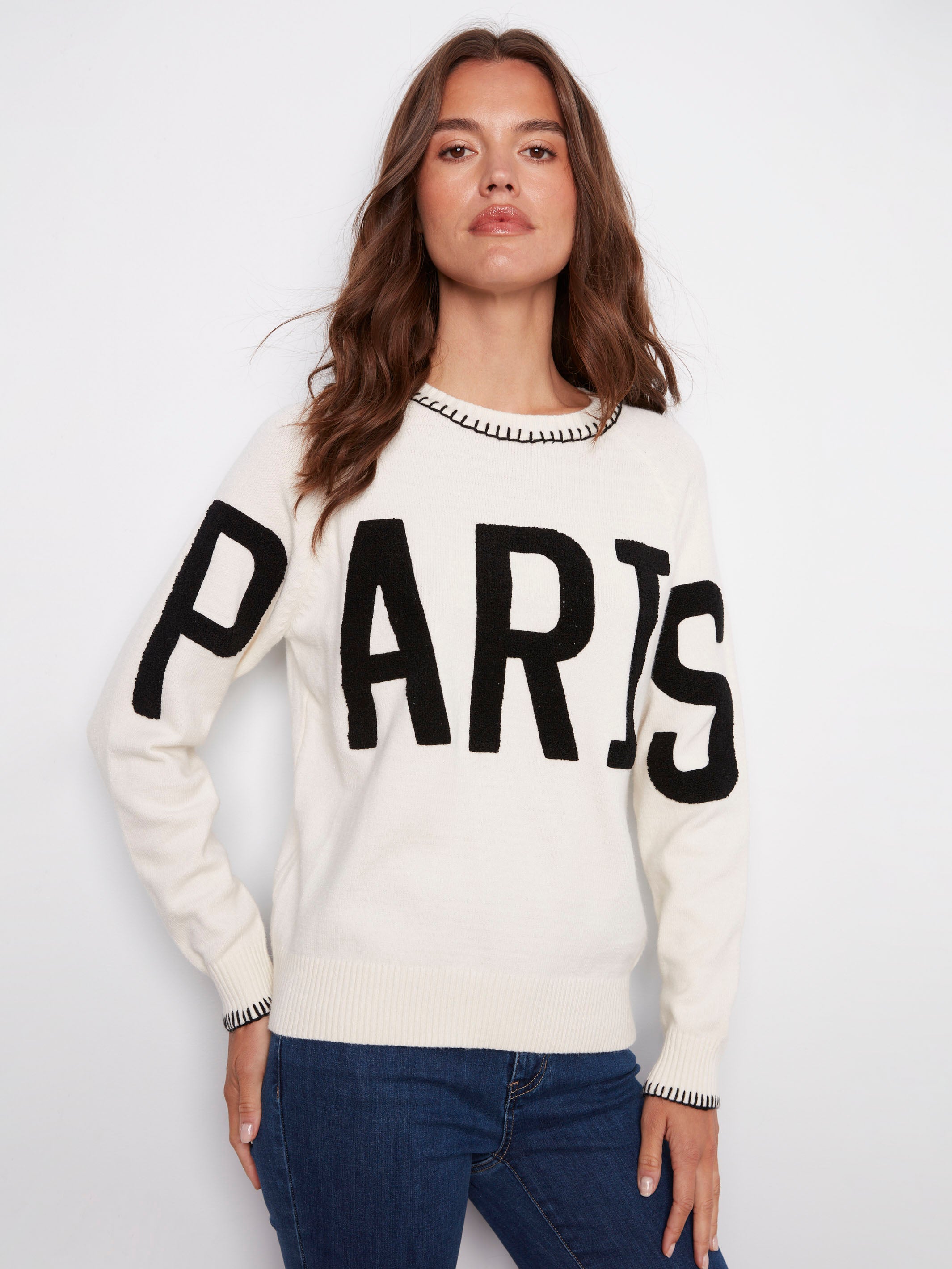 Cozy white sweater showcasing 'PARIS' in boucle embroidery, complete with a classic crew neck design by Charlie B.