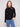 Black slim fit sweater paired with blue jeans, showcasing a stylish mock neck by Charlie B.