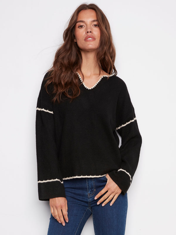 Black long-sleeve sweater featuring drop shoulders and white embroidery for a chic look by Charlie B.