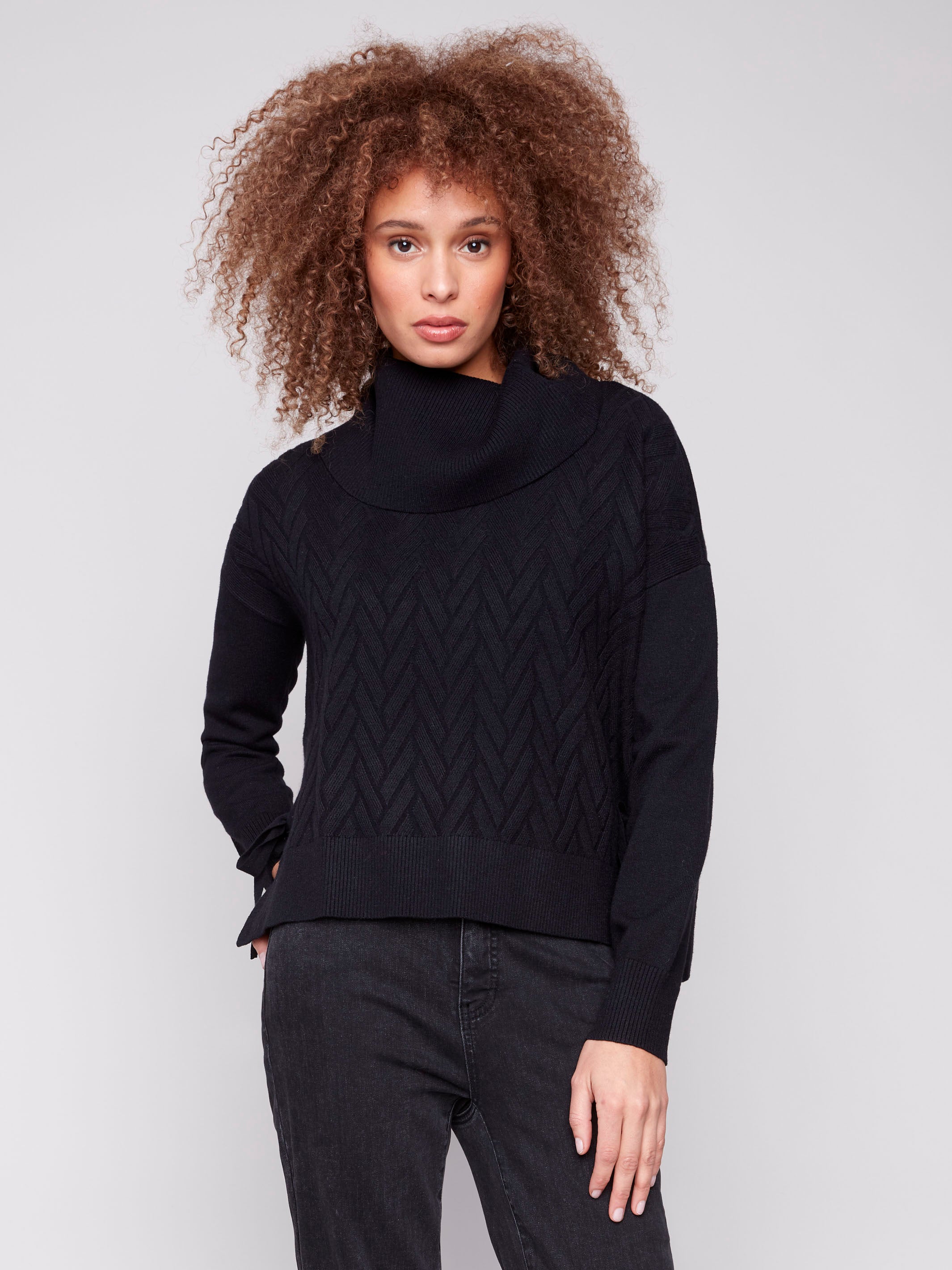 Black sweater with cowl neck and drop shoulders, featuring a chevron pattern. Designed for comfort and style by Charlie B.