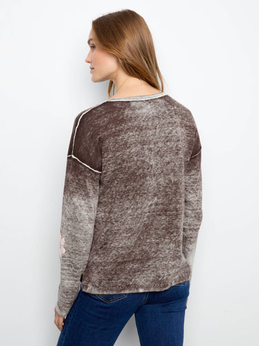 This V-neck design is enhanced with charming flower patterns on the sleeves and body for added flair by Charlie B.