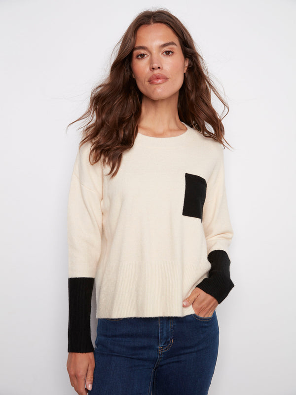 Ecru sweater featuring a classic crew neck design, highlighted by its stylish contrast black pocket by Charlie B.