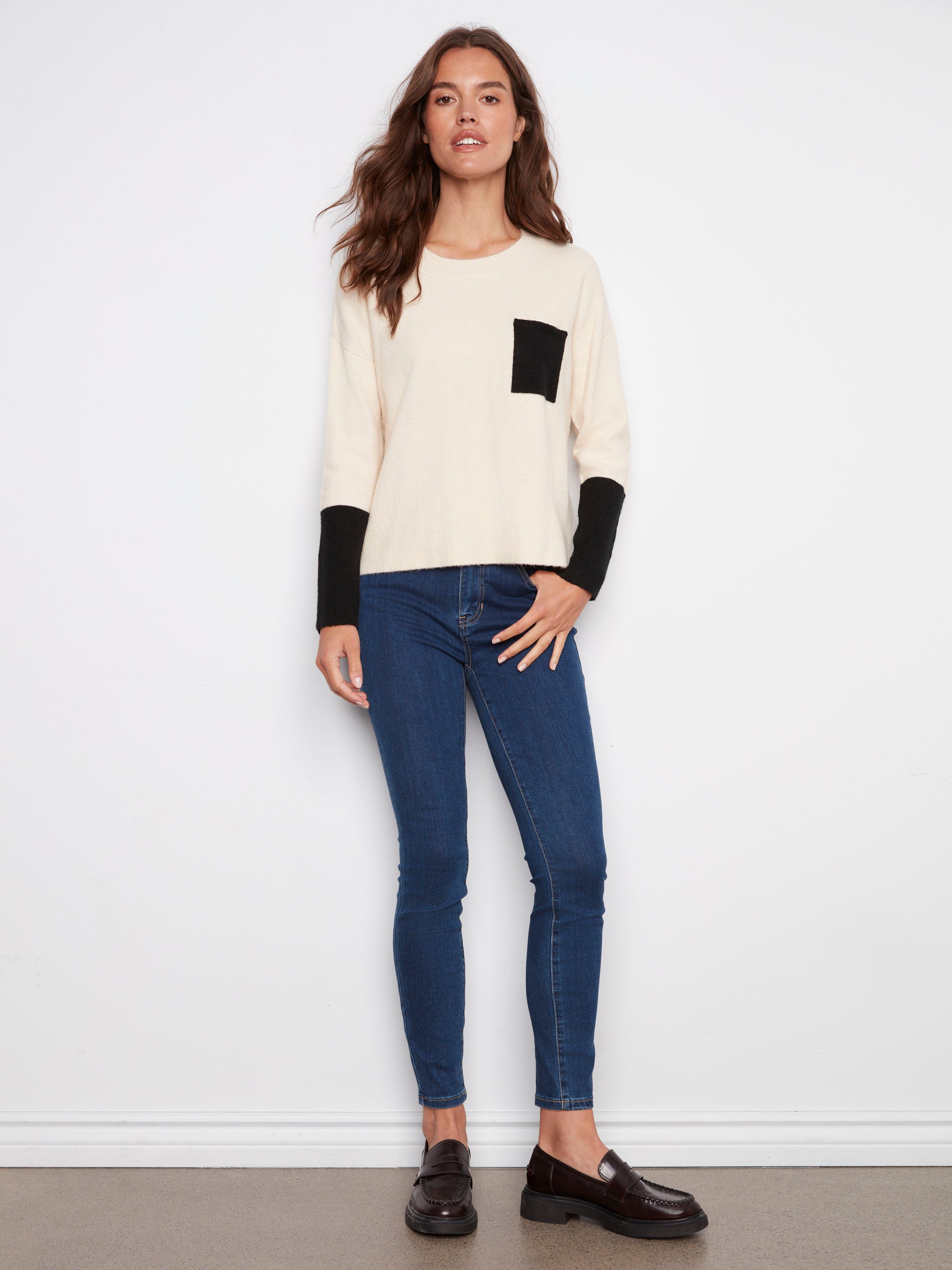 Long sleeves with contrasting black cuffs add a chic touch to this ecru sweater, perfect for any wardrobe by Charlie B.
