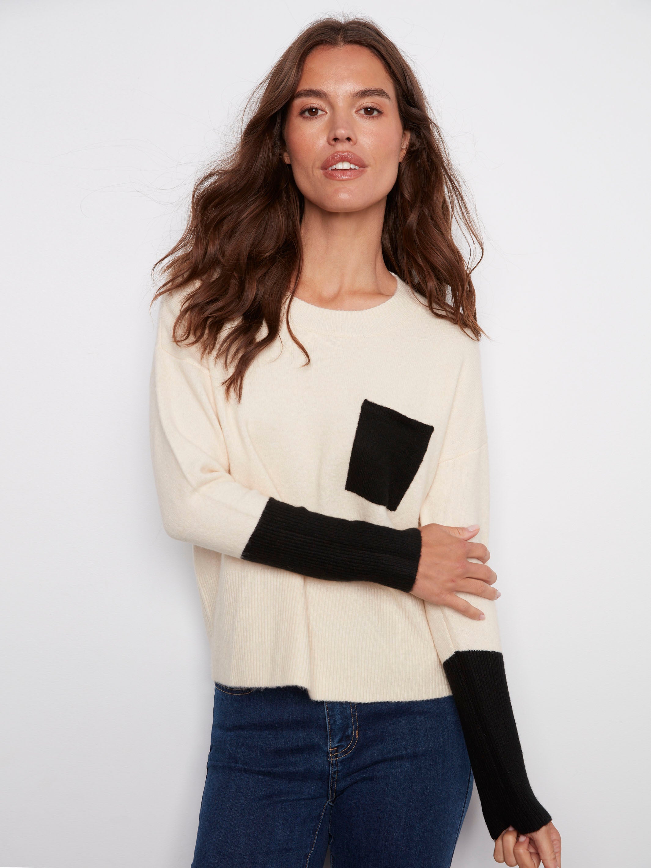 The standout feature of this sweater is its contrast black chest pocket, adding modern flair to the ecru fabric by Charlie B.
