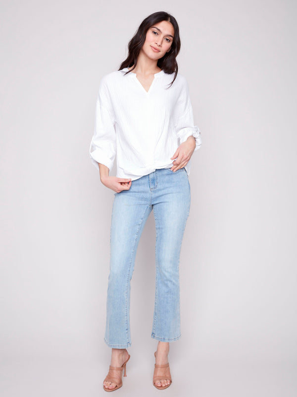 Versatile white blouse with adjustable sleeves, offering both comfort and style by Charlie B.