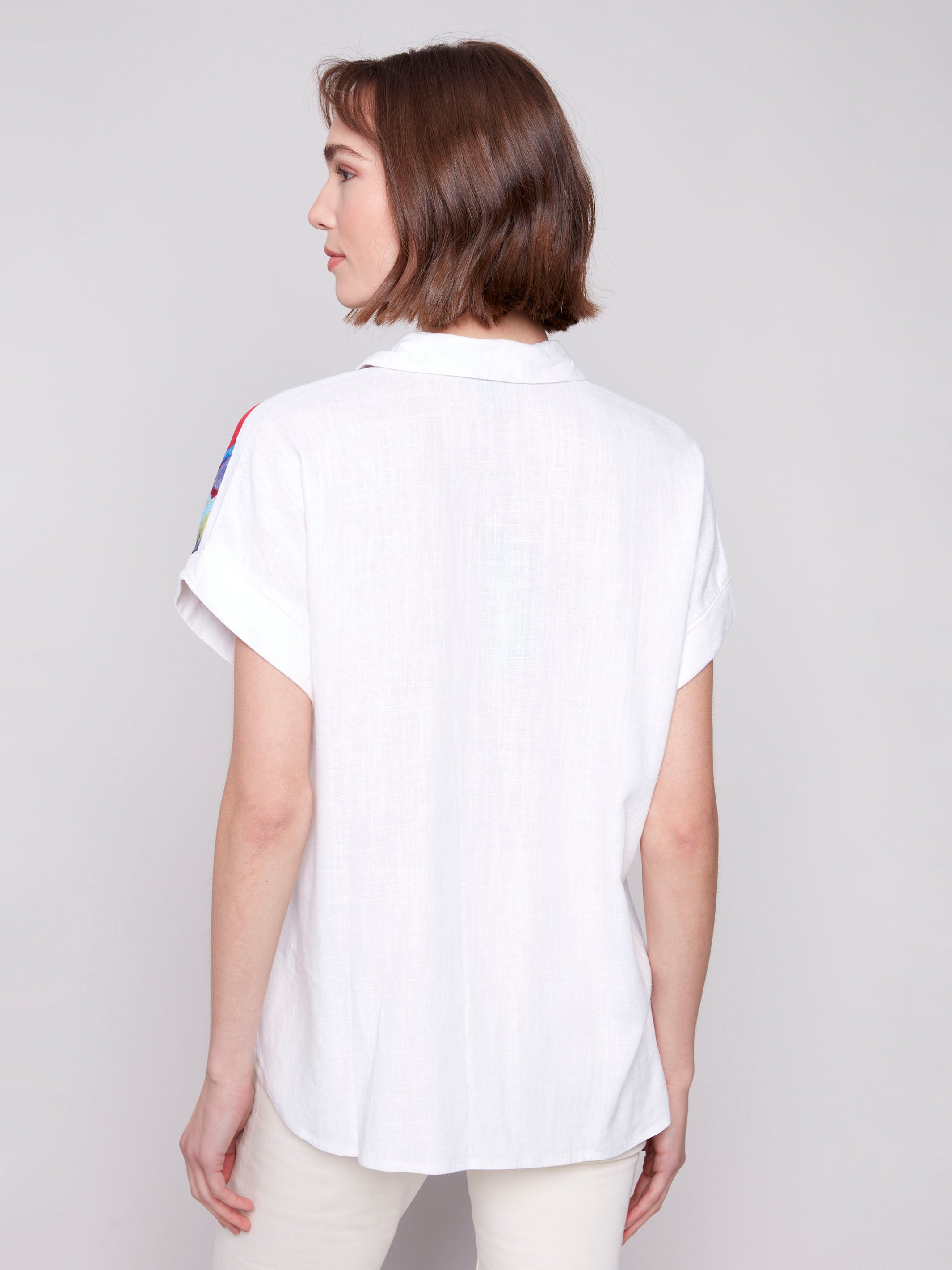 Dolman short sleeves add flair to this feather print shirt by Charlie B.