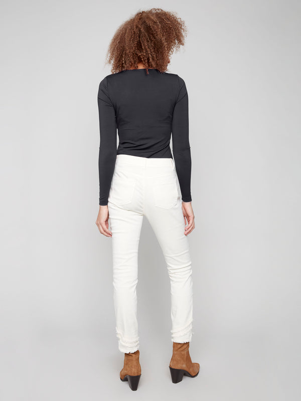 Natural-colored skinny twill pants with frayed hem, featuring a regular rise and five-pocket design by Charlie B.