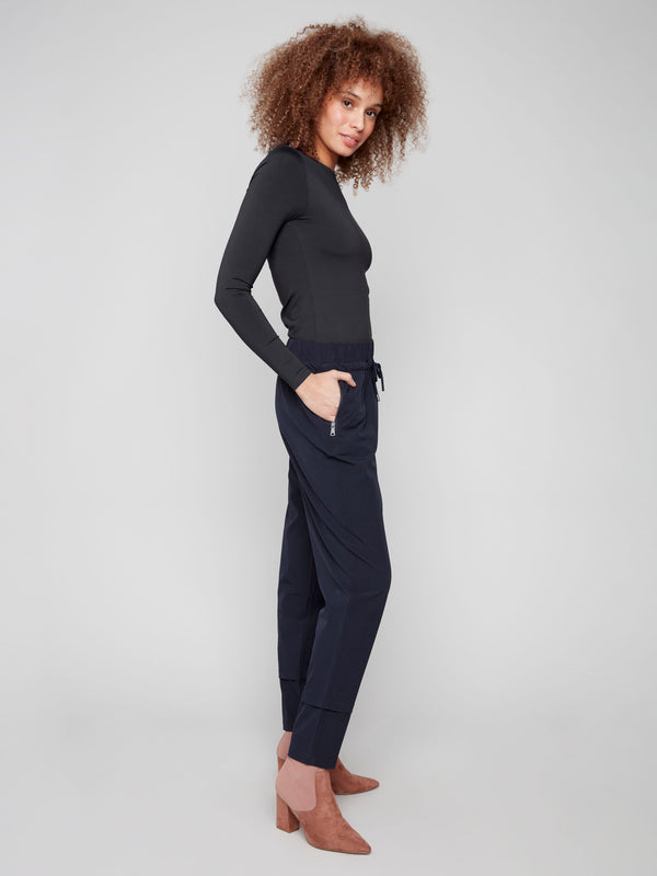 These pull-on style navy pants come with convenient side zip pockets for added functionality by Charlie B.