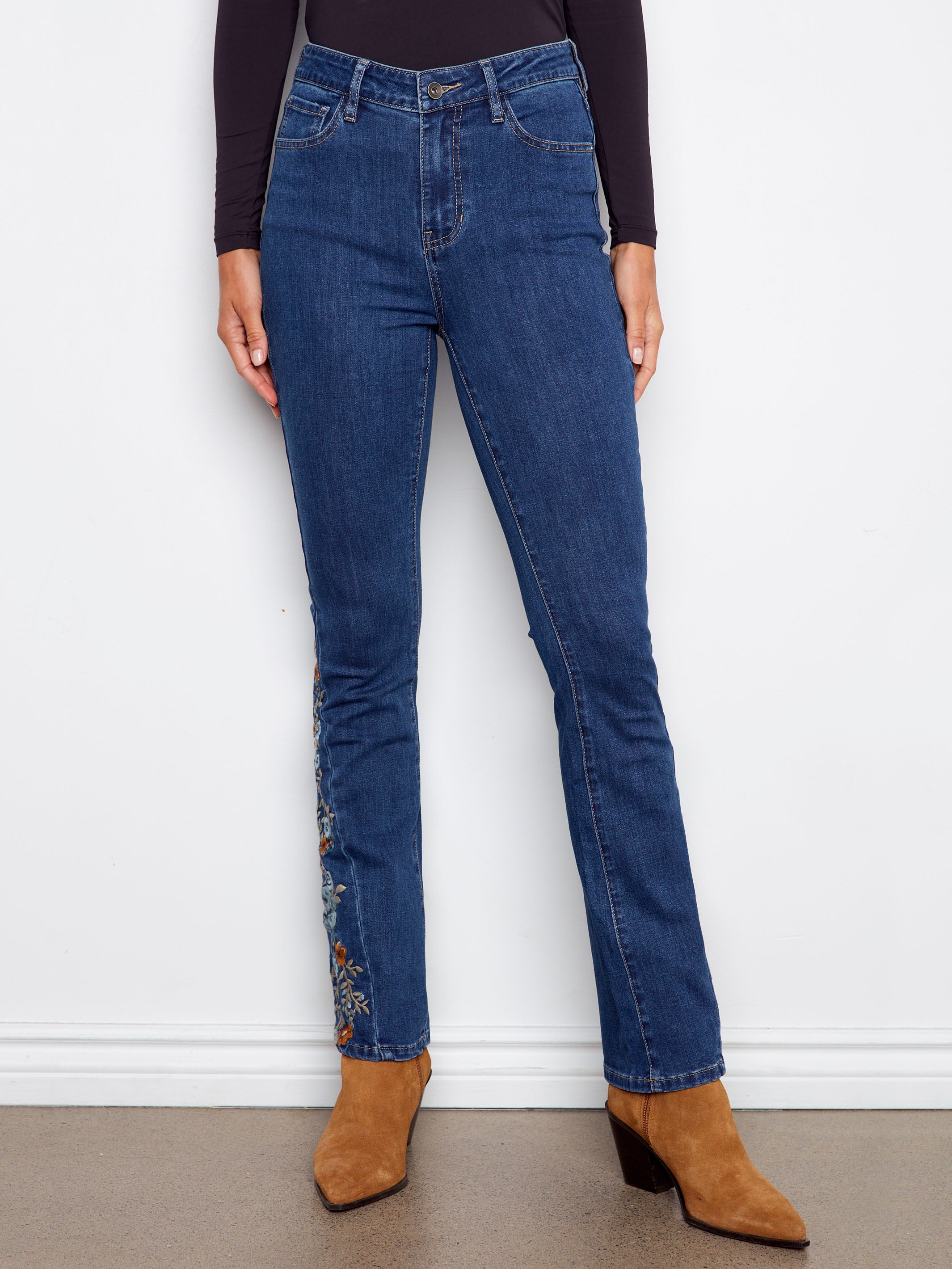 These indigo jeans feature a five-pocket design and elegant floral embroidery for added charm by Charlie B.