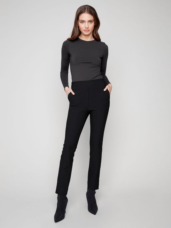 Black slim-fit dress pants with stretch fabric, featuring two back welt pockets for added style and comfort by Charlie B.