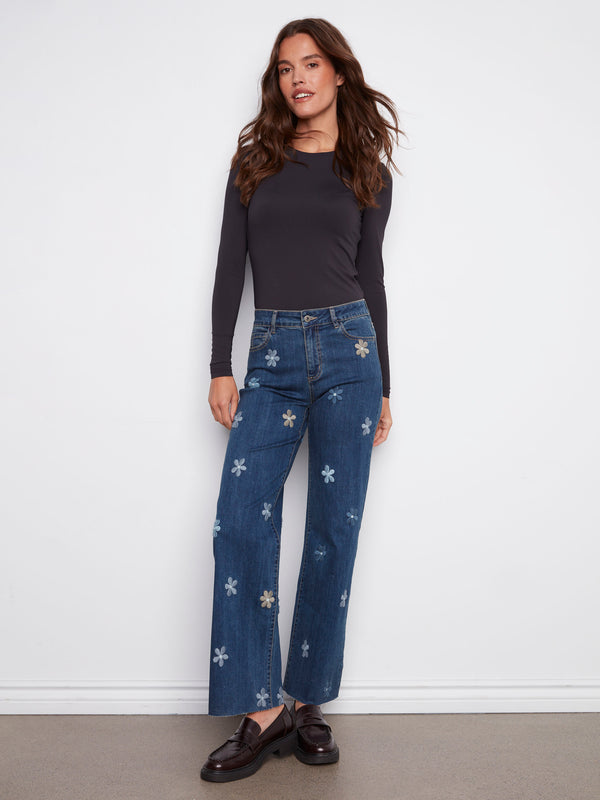Indigo denim pants adorned with five-pocket design and cute flower details, ideal for versatile styling by Charlie B.