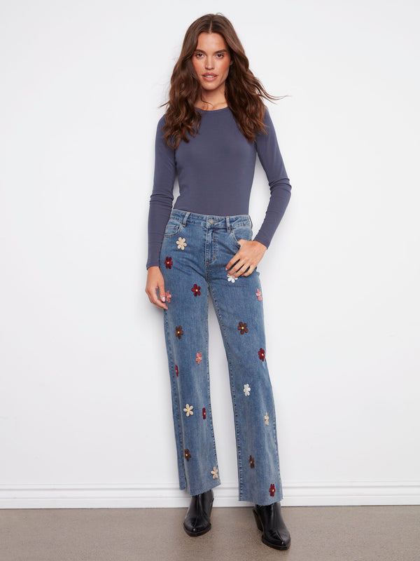 Medium blue jeans featuring a stylish raw hem and floral patches, perfect for casual outings by Charlie B.