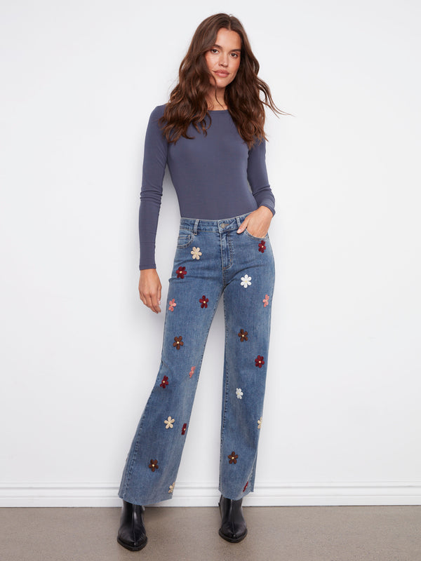 Medium blue jeans with a chic five-pocket design and vibrant flower accents for added flair by Charlie B.