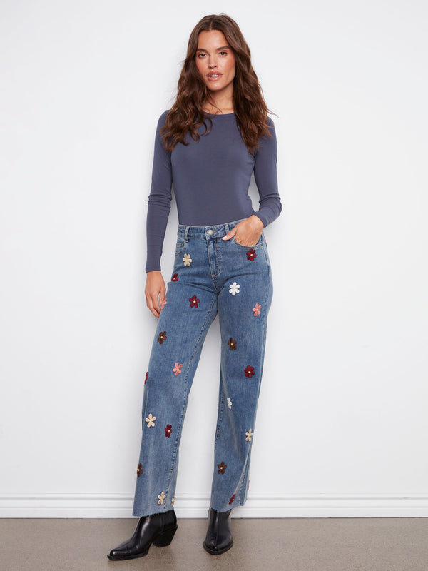 Stylish wide leg jeans in medium blue featuring unique raw hems and floral details for a trendy touch by Charlie B.