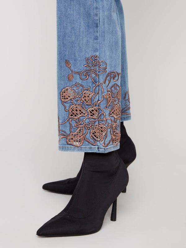Stylish medium blue denim pants crafted from stretch fabric, ensuring ease of movement and adorned with intricate lace patterns by Charlie B.