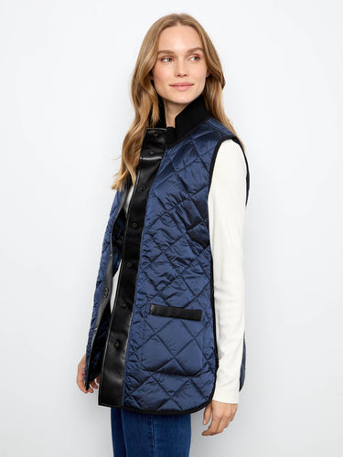 Elegant sleeveless quilted vest with stand collar, ideal for transitional weather layering. By Charlie B.