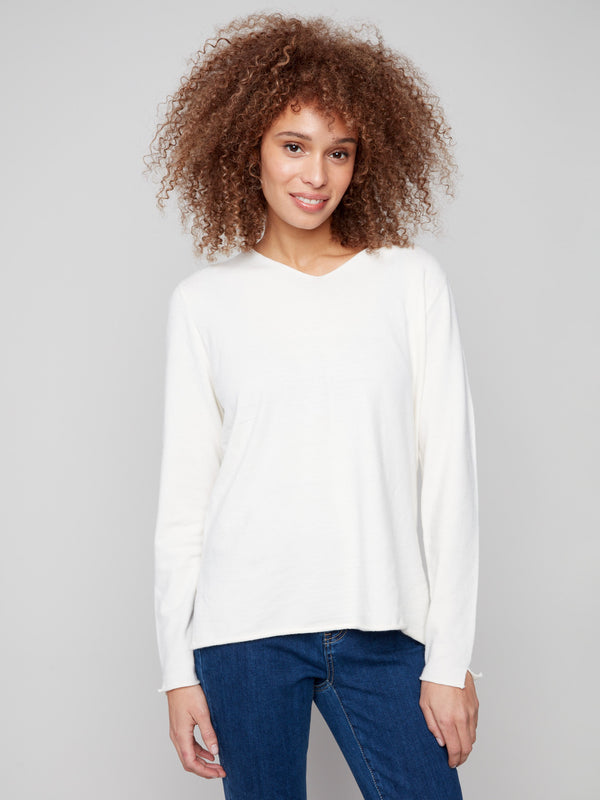 Ecru sweater with V neckline and plush texture, featuring side slits on sleeves for added style by Charlie B.