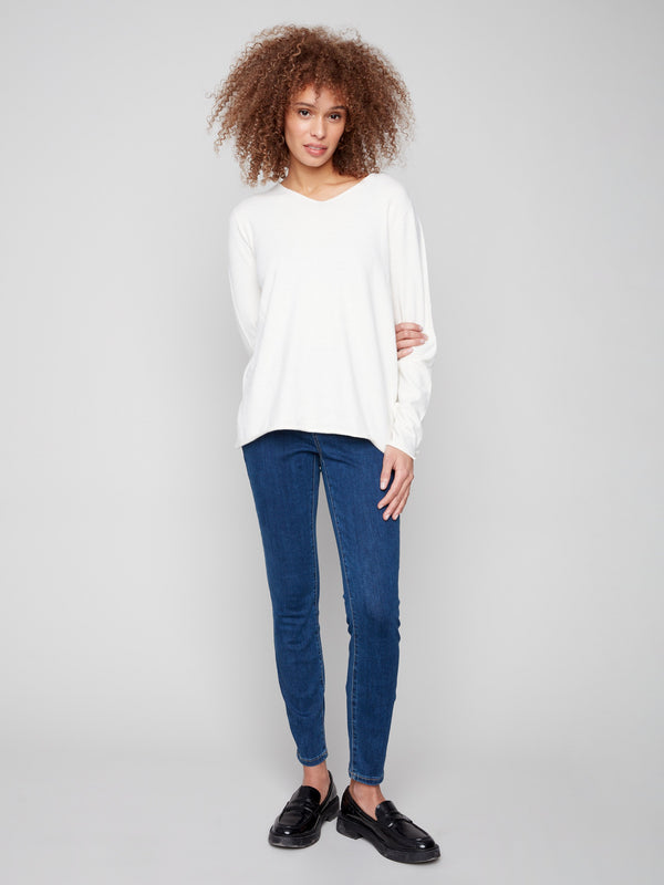 Classic fit ecru sweater with stylish side slits on the hem, offering a modern twist to a timeless design by Charlie B.