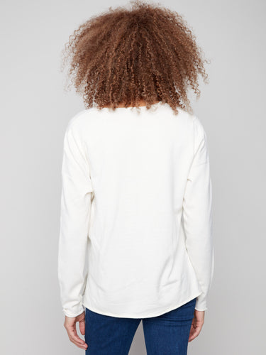 Soft ecru V-neck sweater highlighting its luxurious plush texture and subtle side slits for enhanced comfort by Charlie B.