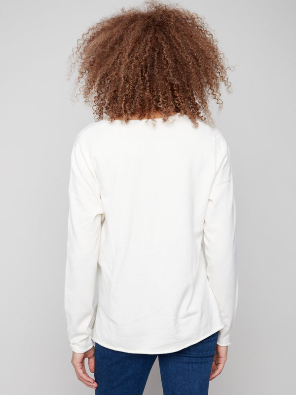 Soft ecru V-neck sweater highlighting its luxurious plush texture and subtle side slits for enhanced comfort by Charlie B.