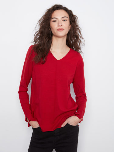 Designed with side slits, this red top combines functionality with modern style. By Charlie B.