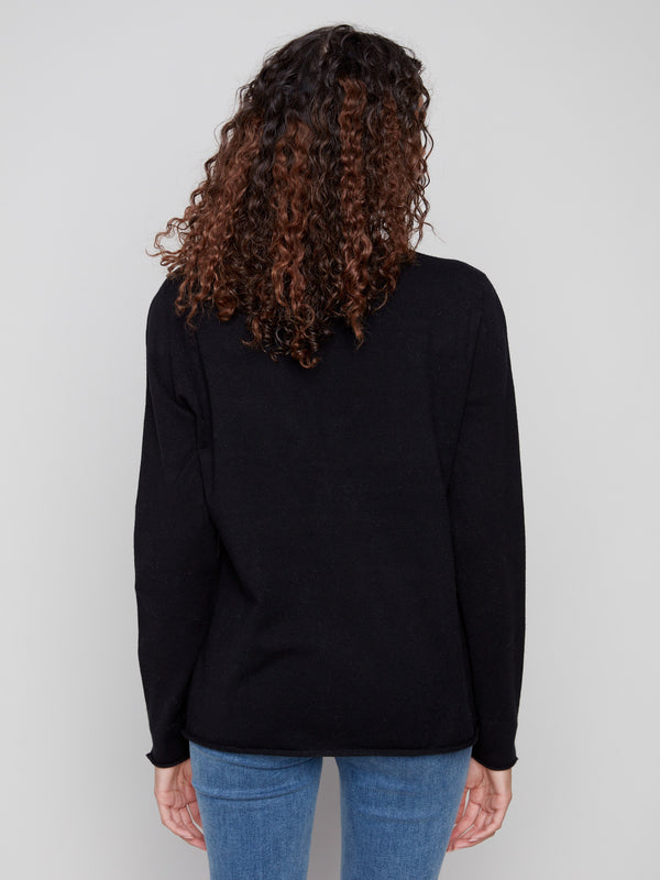 Stylish black sweater with side slits on sleeves and hem, adding a unique touch to the design by Charlie B.