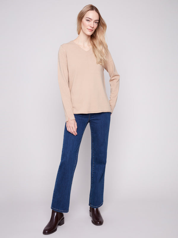 Elegant sesame V-neck sweater featuring side slits on sleeves and hem for added flair by Charlie B.