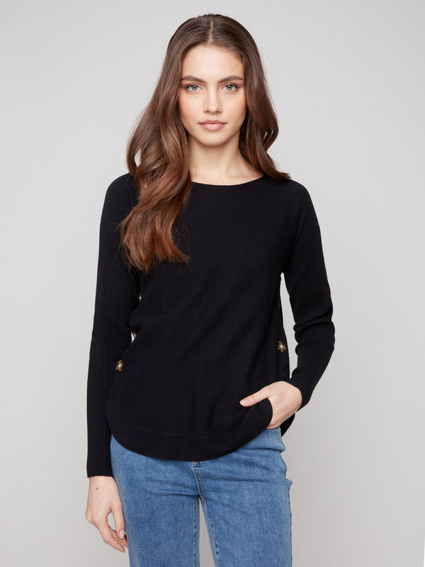 Elegant black sweater with a boat neck design, ideal for sophisticated outings. Features ribbed sleeves for added texture by Charlie B.