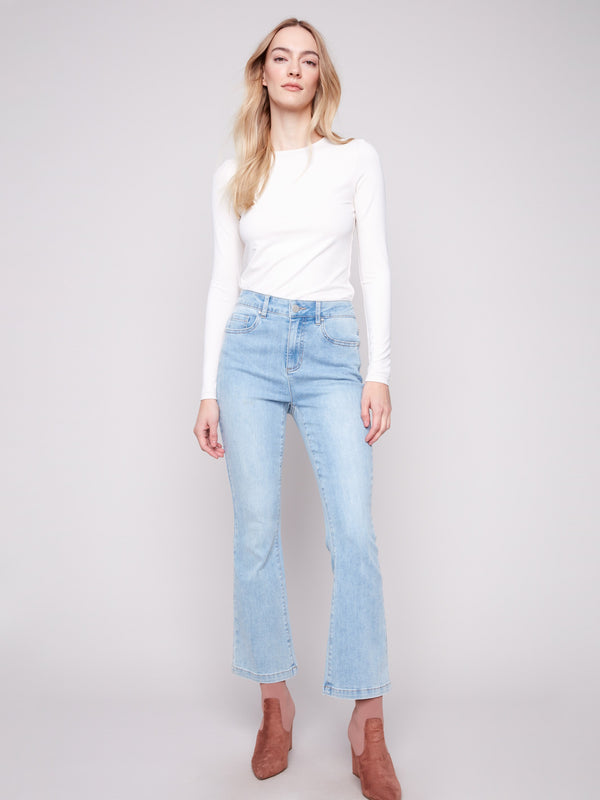 Light blue bootcut denim pants by Charlie B with a classic five-pocket design and regular rise.