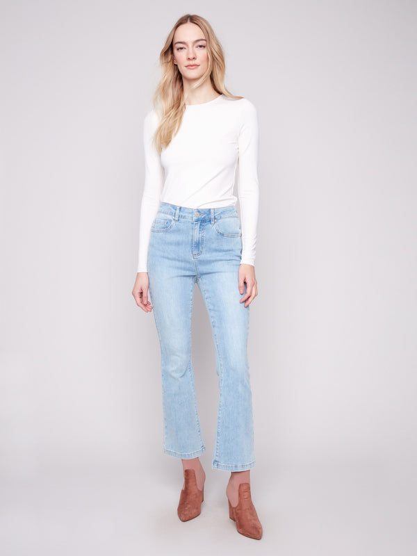 Light blue bootcut denim pants by Charlie B with a classic five-pocket design and regular rise.