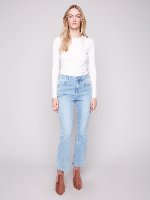 Light blue bootcut denim pants by Charlie B with a classic five-pocket design and regular rise.