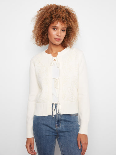 Ecru cardigan featuring a crew neckline and soft jacquard knit texture, accented with tie-front bows by Charlie B.