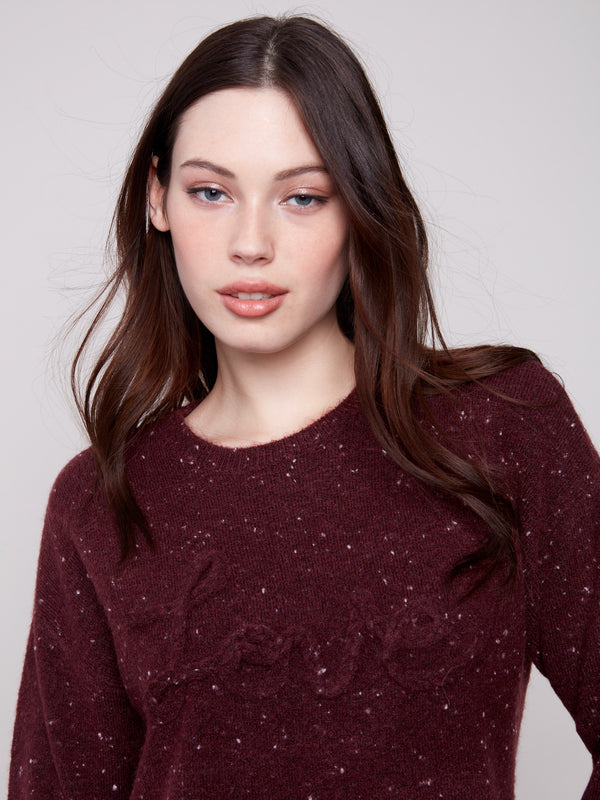 Rich cabernet sweater showcasing the braided 'Love' detail on the front, complemented by long sleeves by Charlie B.