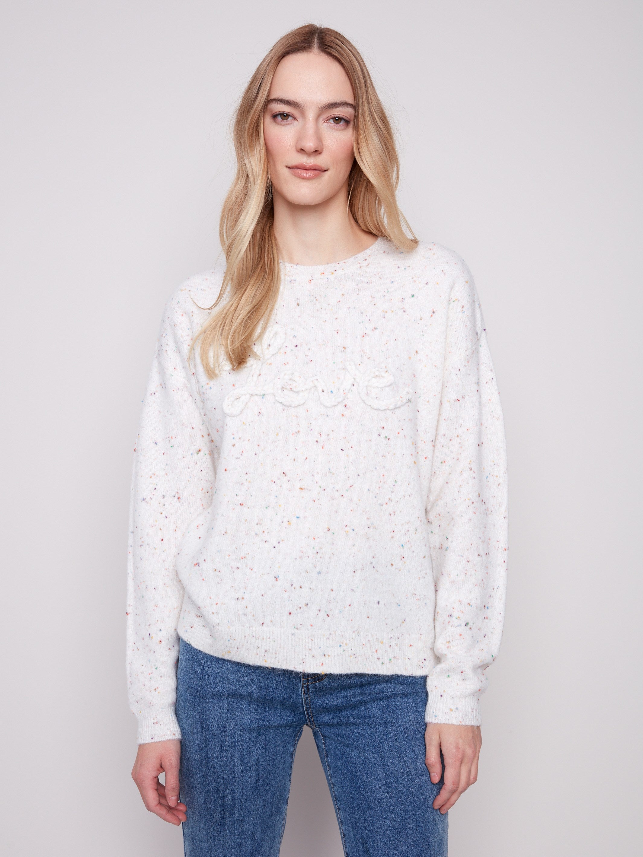 Ecru sweater with a crew neck, showcasing a charming braided 'Love' detail and colorful speckled pattern by Charlie B.