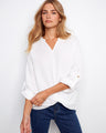 White blouse in 100% cotton featuring a stylish front knot and chic roll-up sleeves by Charlie B.