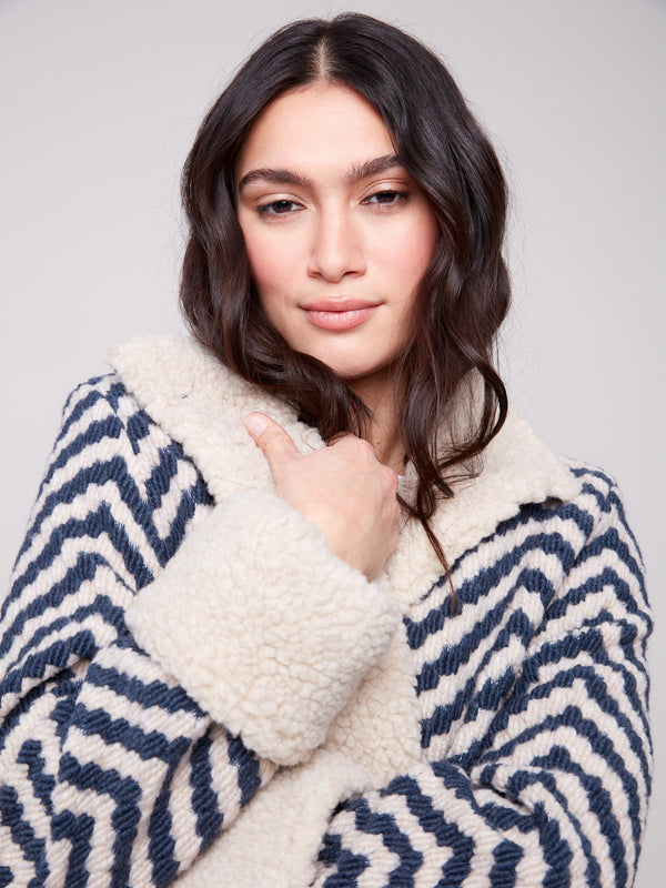 This Navy Chevron Boucle Jacket highlights side pockets for added functionality, while maintaining a fashionable look by Charlie B.