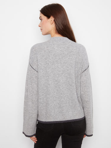 This cozy gray sweater features contrast trim that highlights the unique design elements, adding sophistication to your wardrobe by Charlie B.
