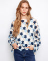 Crochet top with a charming boat neckline, featuring intricate floral patterns and vibrant blue hues. Made with a cotton blend by Charlie B.