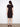 Classic mid-length black dress designed with simplicity and elegance in mind by Charlie B.