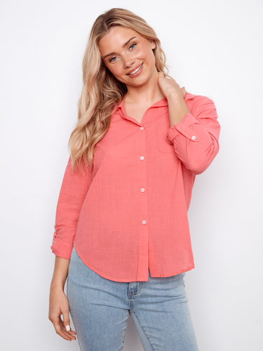 This coral shirt offers adjustable roll-up sleeves, combining style and functionality in pure cotton fabric. Designed by Charlie B.