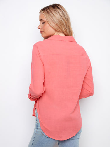 Designed with adjustable roll-up sleeves, this coral shirt provides versatility and comfort in pure cotton fabric. By Charlie B.