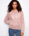 Pink crochet sweater with a hooded design, featuring intricate patterns and soft texture for a cozy feel by Charlie B.