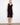 Elegant black dress featuring a V-neckline and sleeveless design, perfect for warm weather occasions. By Charlie B.