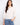 White blouse with a tie at the notched neckline, featuring eyelet detailing and 3/4 sleeves with elastic cuffs by Charlie B.