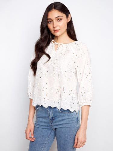 Elegant white blouse with scalloped hem and eyelet pattern. Features 3/4 sleeves and elastic cuffs for comfort by Charlie B.