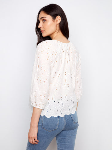Chic blouse adorned with eyelet details, featuring a notched neckline tied elegantly. Scalloped hem adds charm by Charlie B.