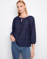 Navy blouse featuring a notched neckline with tie and intricate eyelet detailing, perfect for a stylish look by Charlie B.