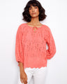 Featuring a notched neckline with tie, this coral blouse adds a touch of elegance to any outfit. By Charlie B.