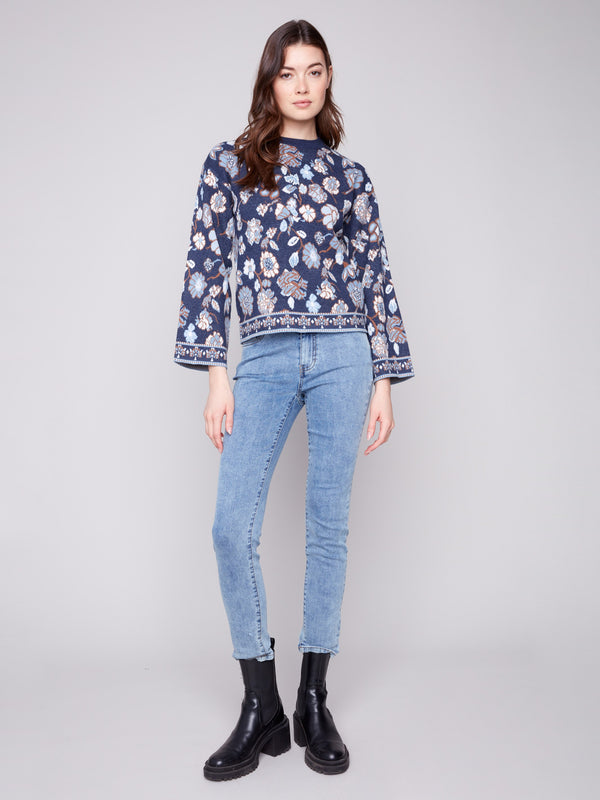 Stylish navy sweater showcasing intricate floral jacquard and comfortable dolman sleeves by Charlie B.