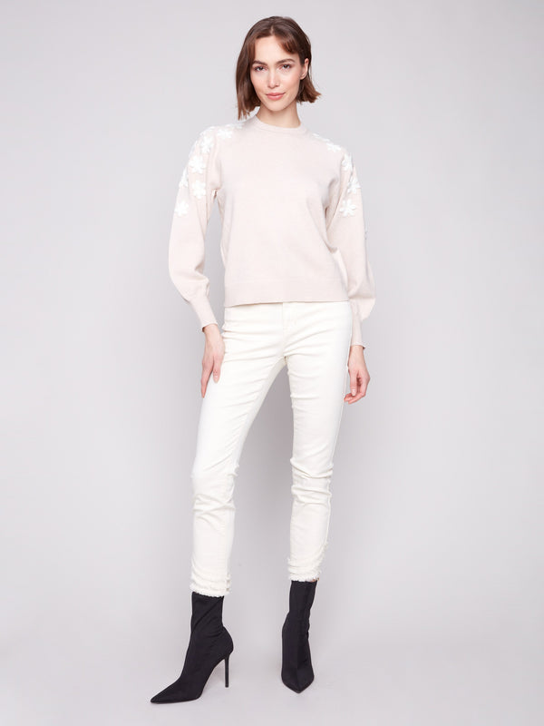Classic crew neck design complements the white embroidered florals on this elegant sweater by Charlie B.